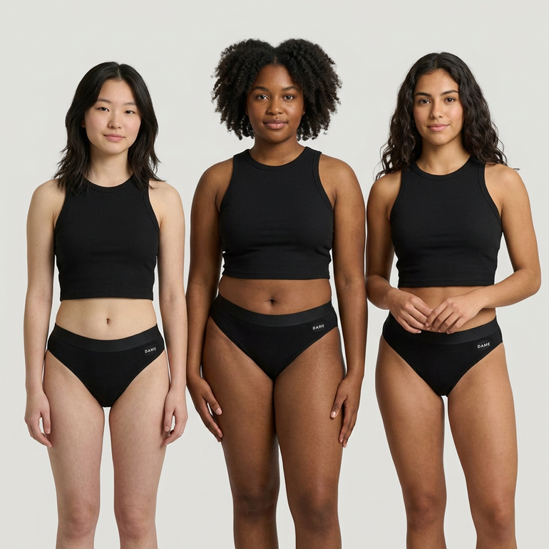 Three models wearing a matching black two-piece activewear set consisting of a cropped tank top and high-waisted briefs, shown against a solid light gray background.