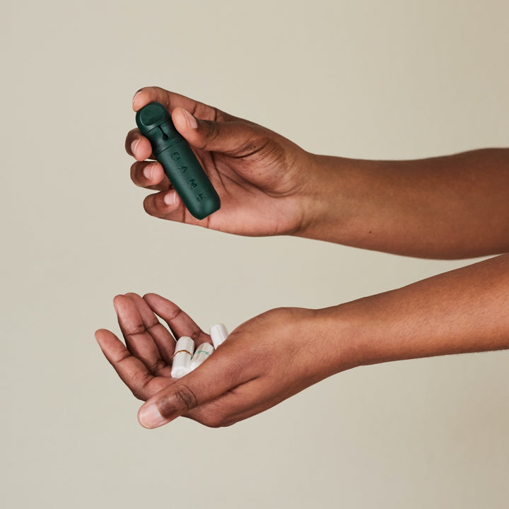 DAME reusable applicator in hands with organic tampons